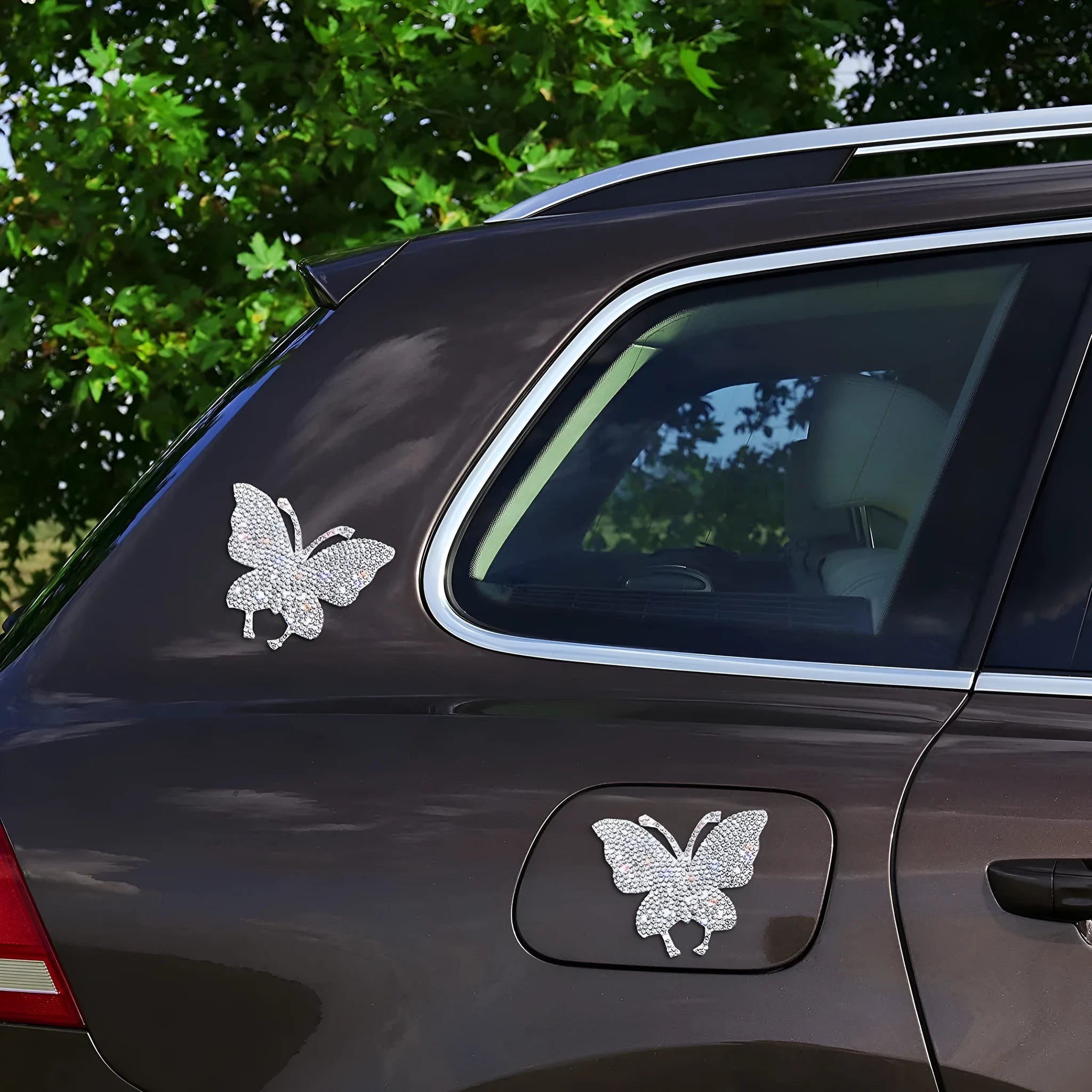 Close-up of a diamond-encrusted glass car sticker in a bear paw design on a car window.