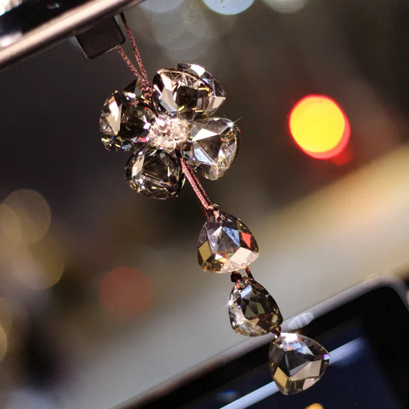 Crystal four leaf grass car pendant hanging, shown in different colour options including transparent and champagne.