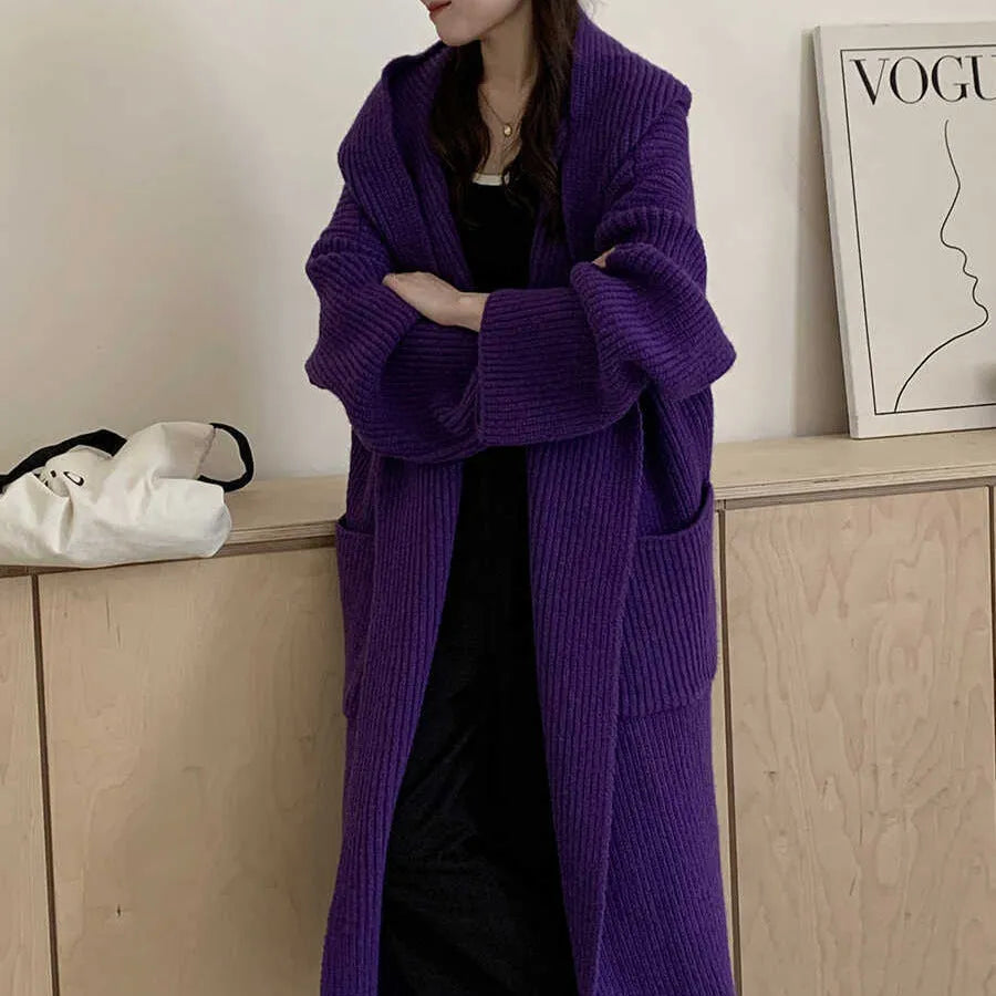 Loose-fitting beige hooded cardigan coat for women with raglan sleeves on a hanger.