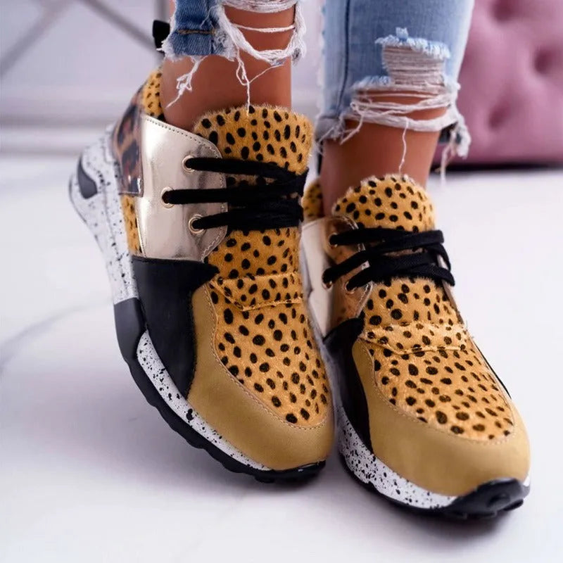 Women's black suede casual sneakers with a low wedge heel and round toe on a white background.