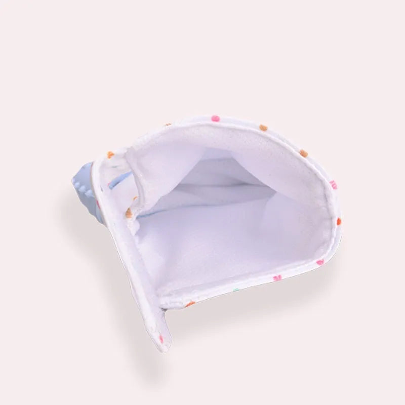 BPA-free silicone baby teether glove fastened with a white Velcro strap on a baby's hand