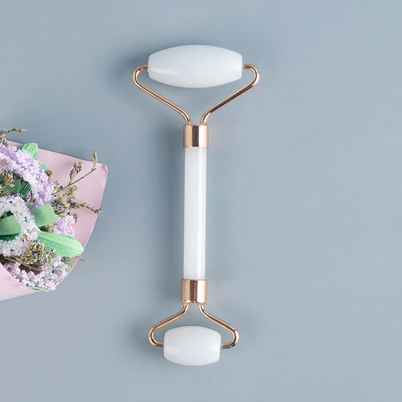 White jade double-headed roller and matching scraping board set on a flat surface.