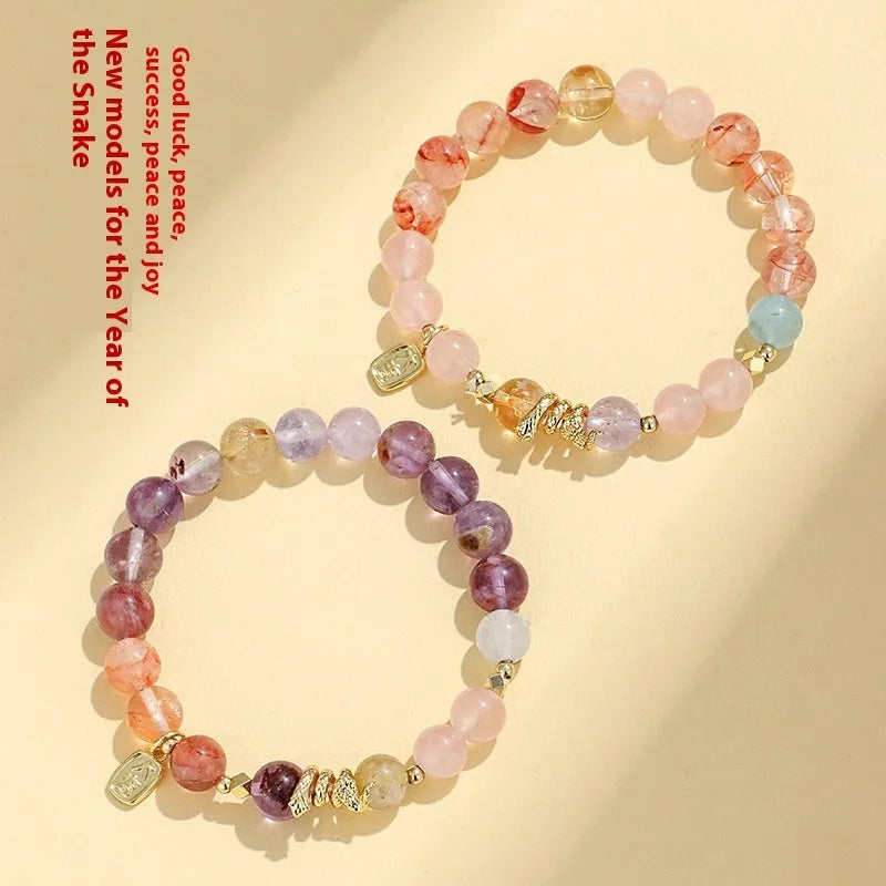 Women's crystal bracelet with Fu snake charm and plastic flower beads on wrist
