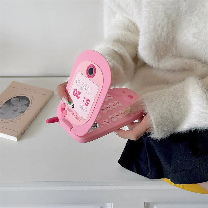 Light pink silicone flip phone case with built-in mirror for iPhone on a table