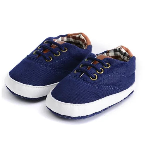 Solid colour baby canvas shoes with a front strap, shown in light grey on a white background.