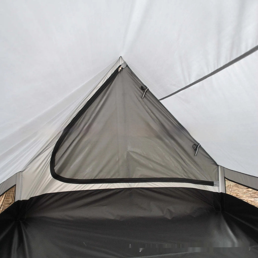Brown A-Line pole-free cabin tent set up in a forest, showing its spacious interior for 2-3 people.