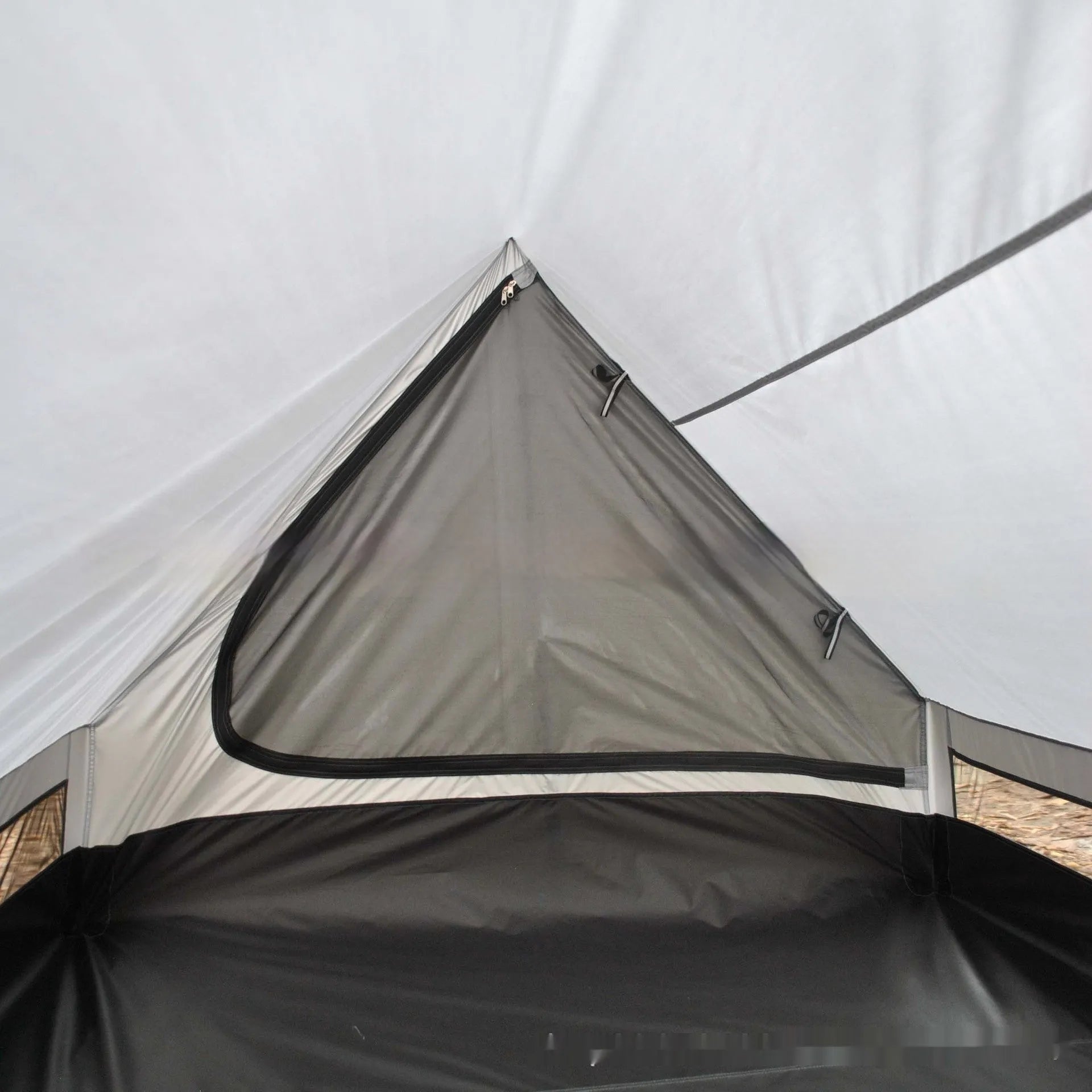 Brown A-Line pole-free cabin tent set up in a forest, showing its spacious interior for 2-3 people.