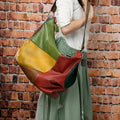 Brown cowhide leather crossbody travel bag open to show a 15-inch laptop and iPad inside.