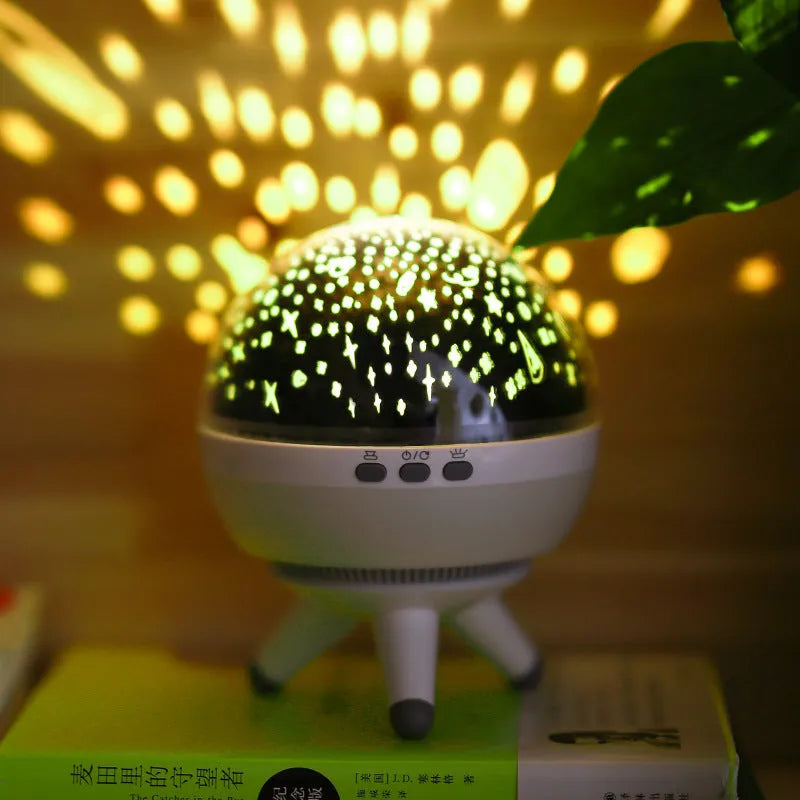 Black and white rotating cartoon-style starlight projection lamp on a surface.