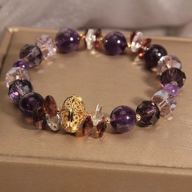 Purple crystal bracelet with pumpkin beads and rhinestone decoration on a wrist.