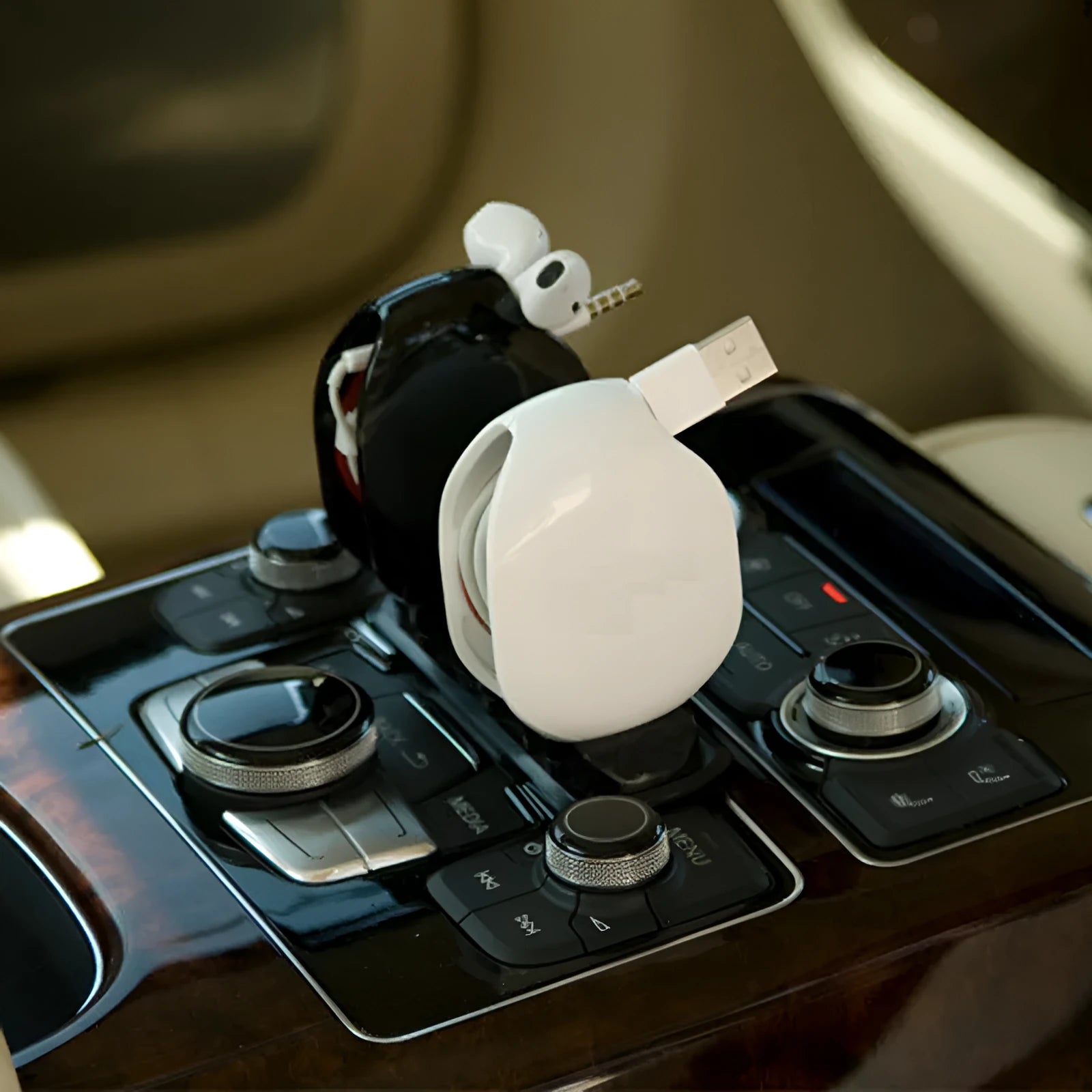 Automatic earphone cable winder unit in blue showing retracted cable, next to a black unit for size comparison.