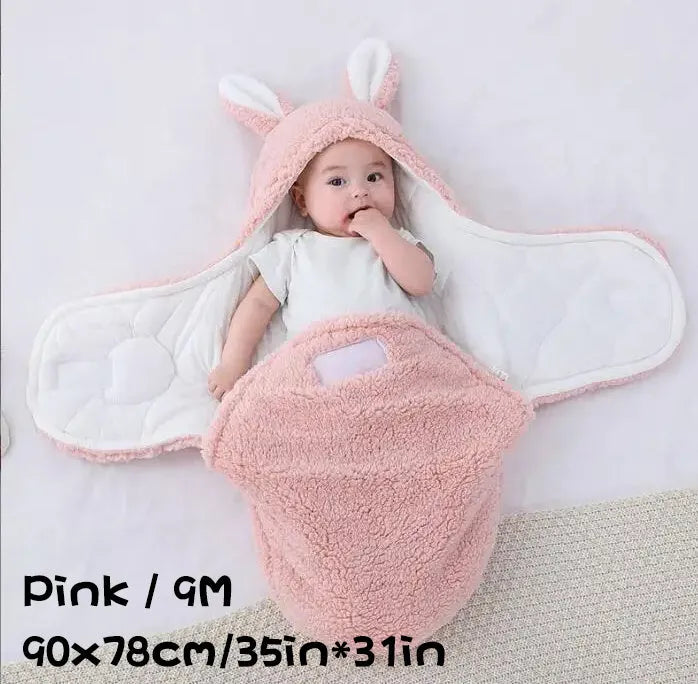 Baby wearing a grey adjustable fleece swaddle sleep sack with velcro wings