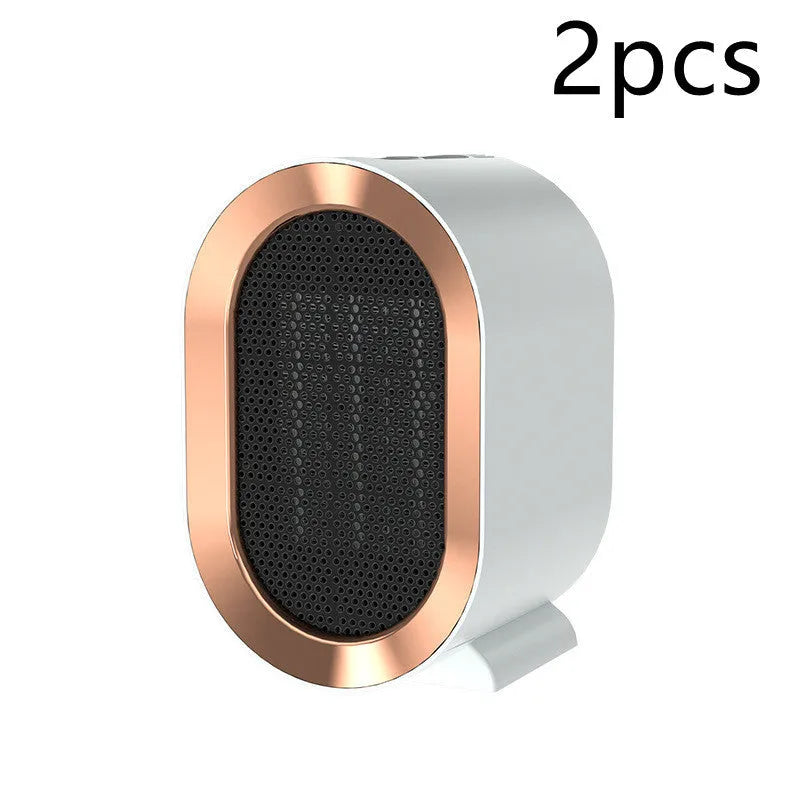 A compact black desktop ceramic fan heater with a mechanical control dial and a UK plug.