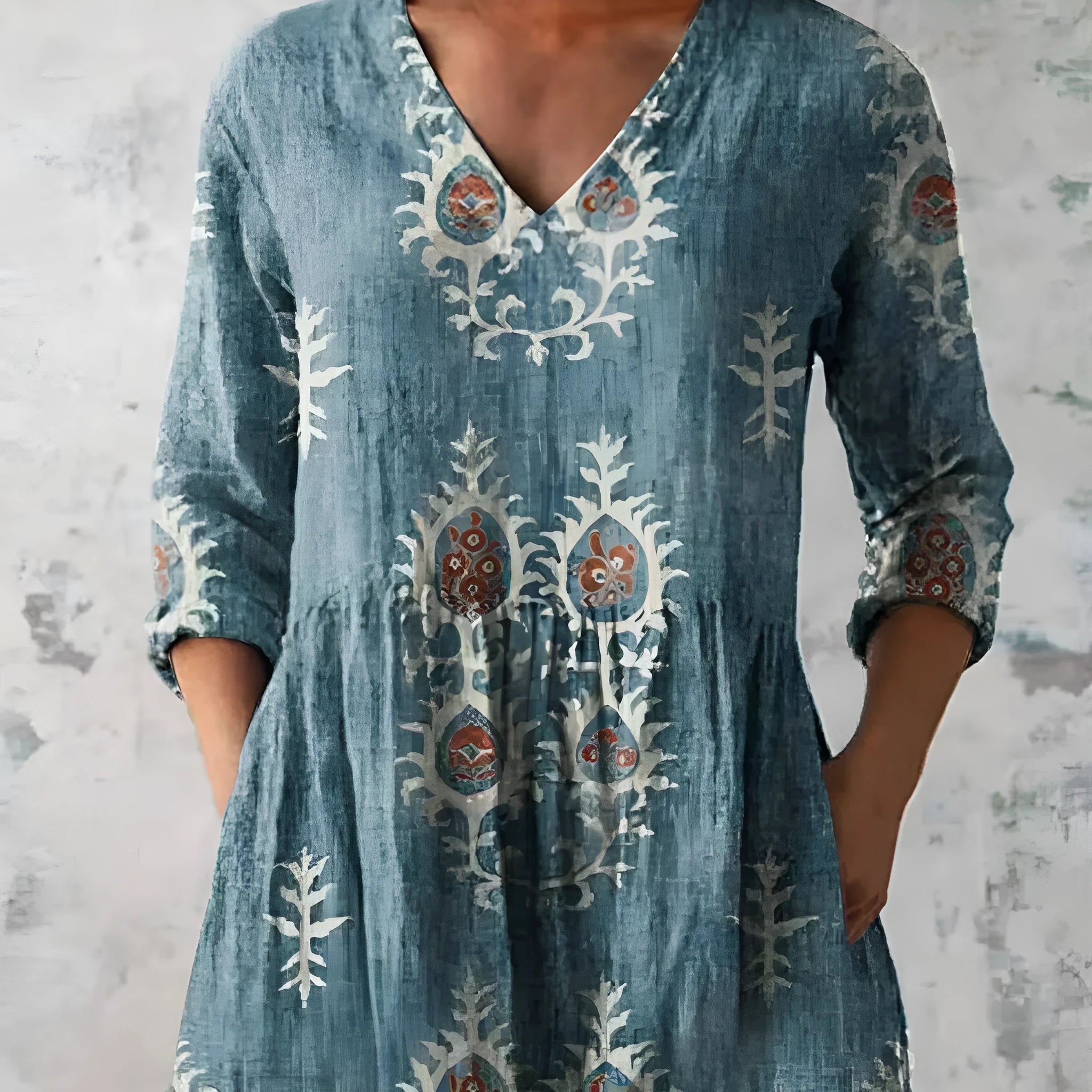A woman wearing a loose-fitting floral print dress with 3/4 ruffle sleeves and a wide waist.