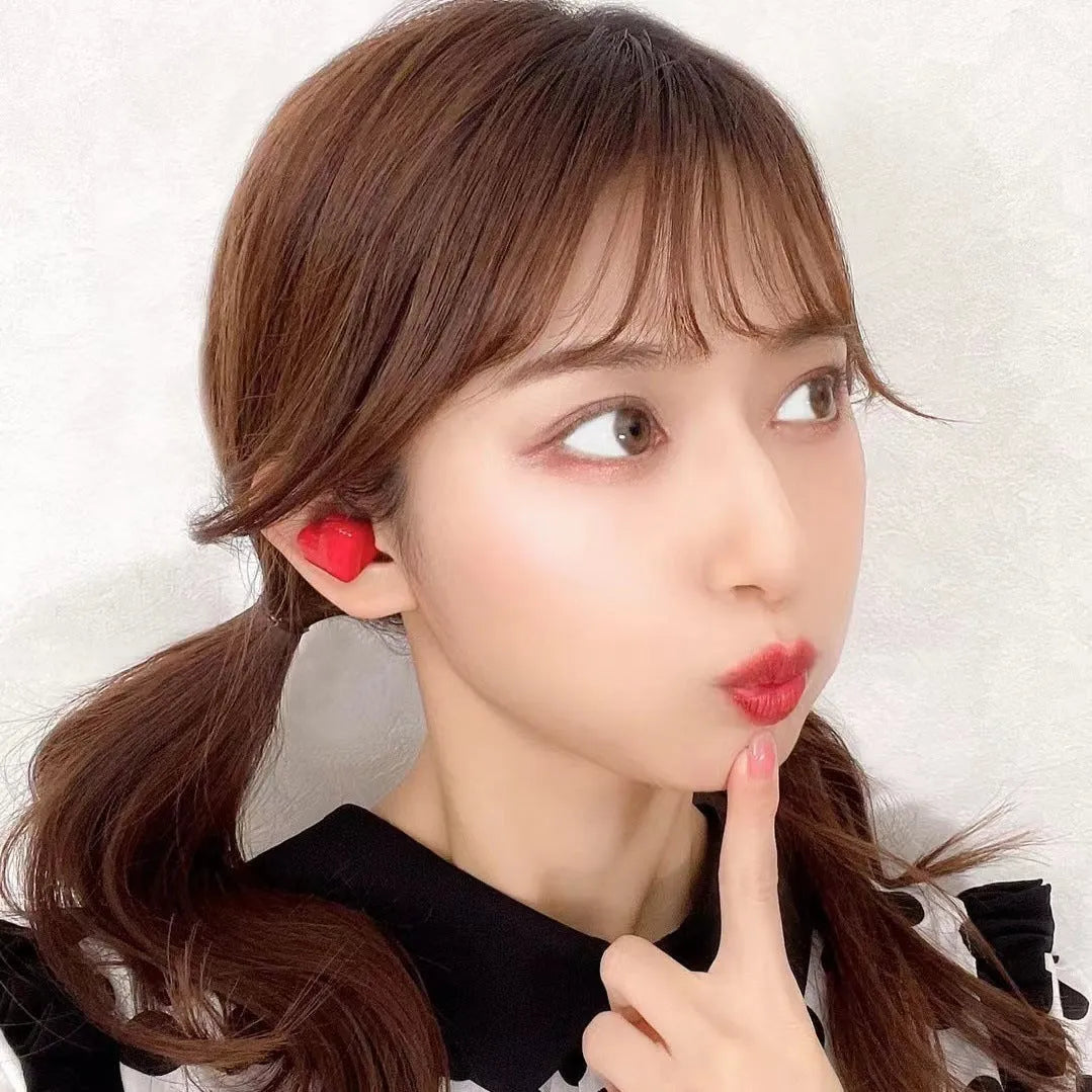 Heart-shaped wireless Bluetooth earbuds in red or pink colours with charging cable
