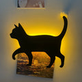 Black cartoon cat shaped LED night light with sound sensor for wall mounting.