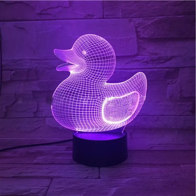 Little yellow duck 3D night light on a table with remote control, displaying a blue colour.