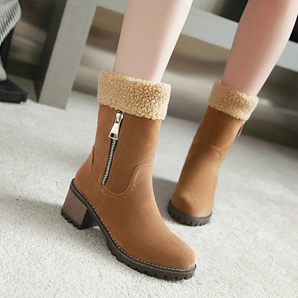 A pair of black snow boots with a plush lining and rubber insole on a winter background.
