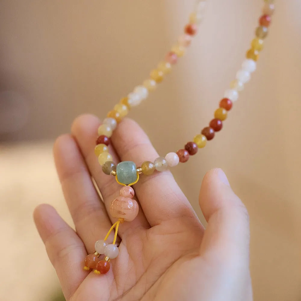 Women's Jinsi Jade bracelet with pumpkin tassel on a 14-16cm wrist.