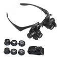 Black double eye magnifying glasses with LED lights and interchangeable lenses on a headband.