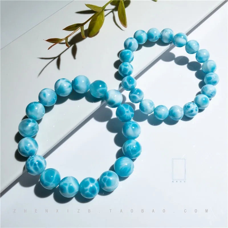 Blue bodhi bracelet with a sea-pattern natural crystal stone and small pearl accents on a wrist.