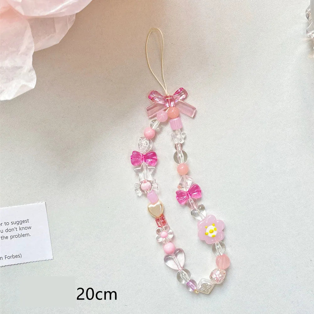 Adjustable rope wrist lanyard with blue plastic flower beads attached to a mobile phone.