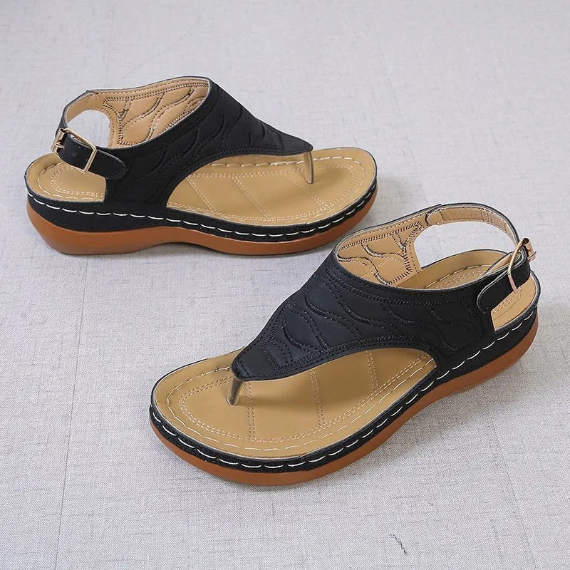 Women's wedge heel flip flop sandals with an adjustable back strap in solid black.