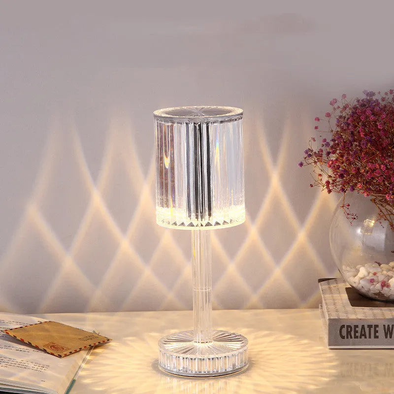Modern crystal table lamp with transparent bead shade and metal stand on wooden surface