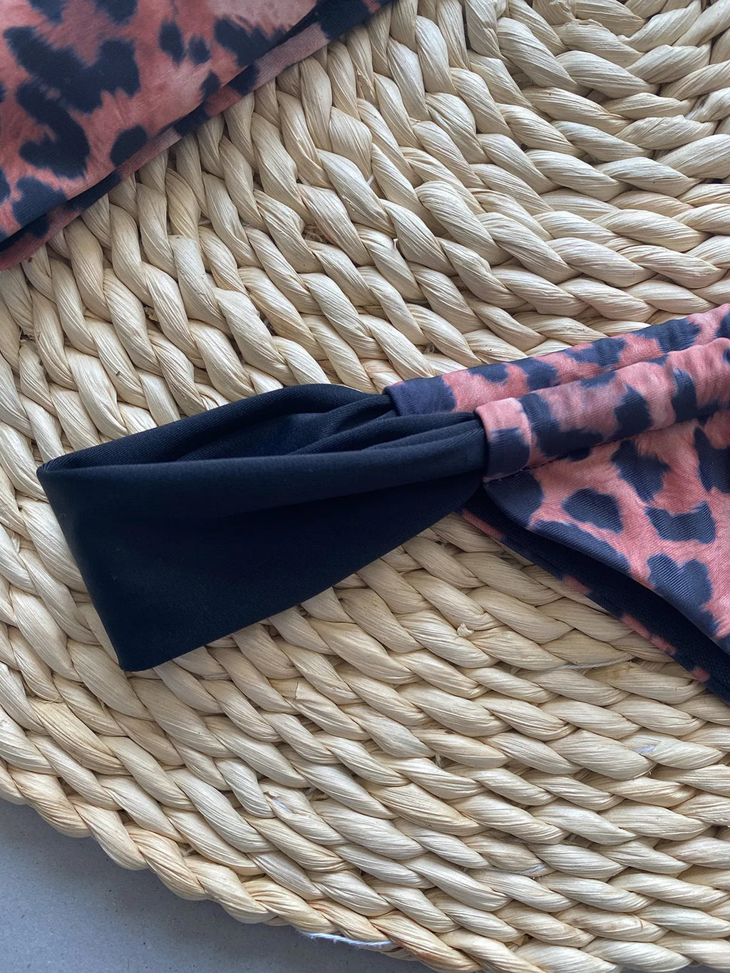 Women's black and leopard print tube top bikini set laid flat, showing the sleeveless top and briefs.