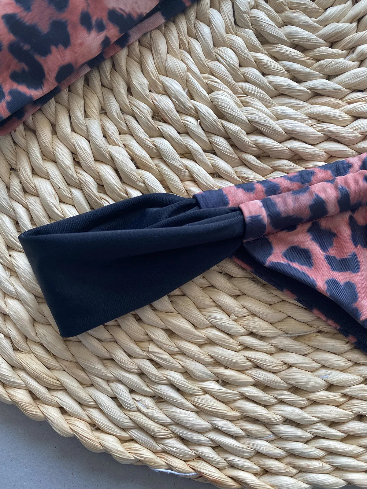 Women's black and leopard print tube top bikini set laid flat, showing the sleeveless top and briefs.
