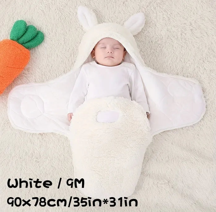 Baby wearing a grey adjustable fleece swaddle sleep sack with velcro wings