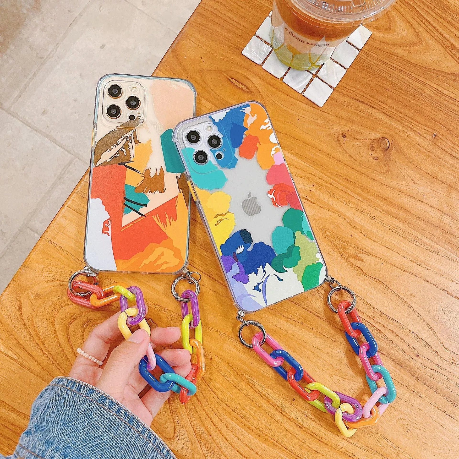 Graffiti design mobile phone case with bracelet strap attached, shown fitting iPhone model