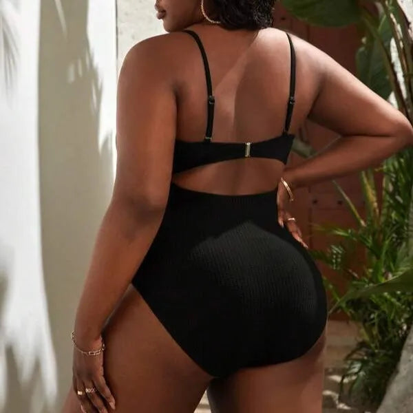 Plus size women's black slimming one-piece swimsuit with triangle sling design