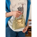 Champagne-gold PU shell bag with stitched seams, shown in shoulder mode against a neutral background