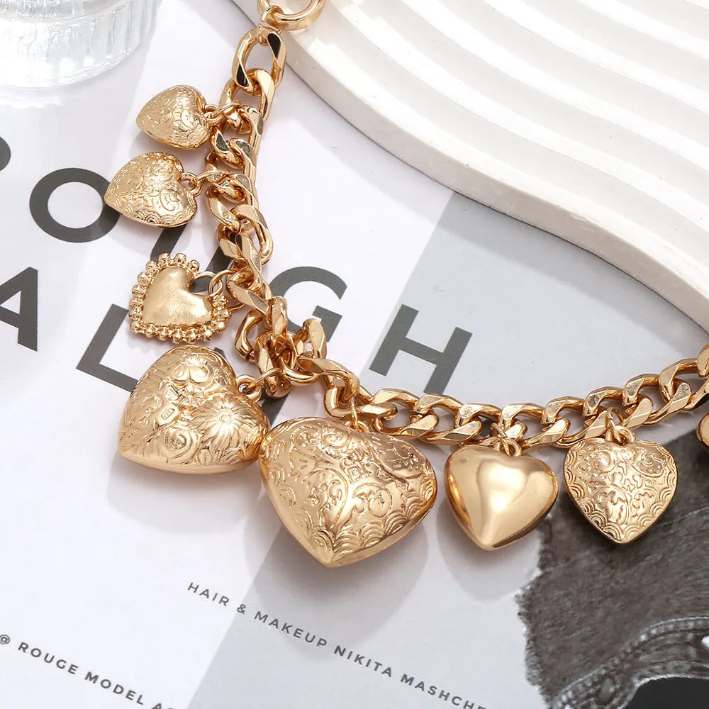 Gold tone carved heart-shaped pendant on an adjustable metal chain necklace.