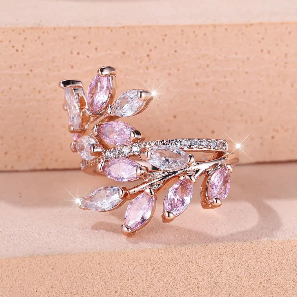 Adjustable copper leaf-shaped ring with sparkling zircon stones in rose gold and platinum finishes.
