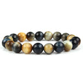 Natural tiger's eye crystal bracelet with round geometric beads in various colours and sizes on a wrist.