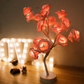 White and red rose flower shaped USB battery LED table lamp with warm white light on a table
