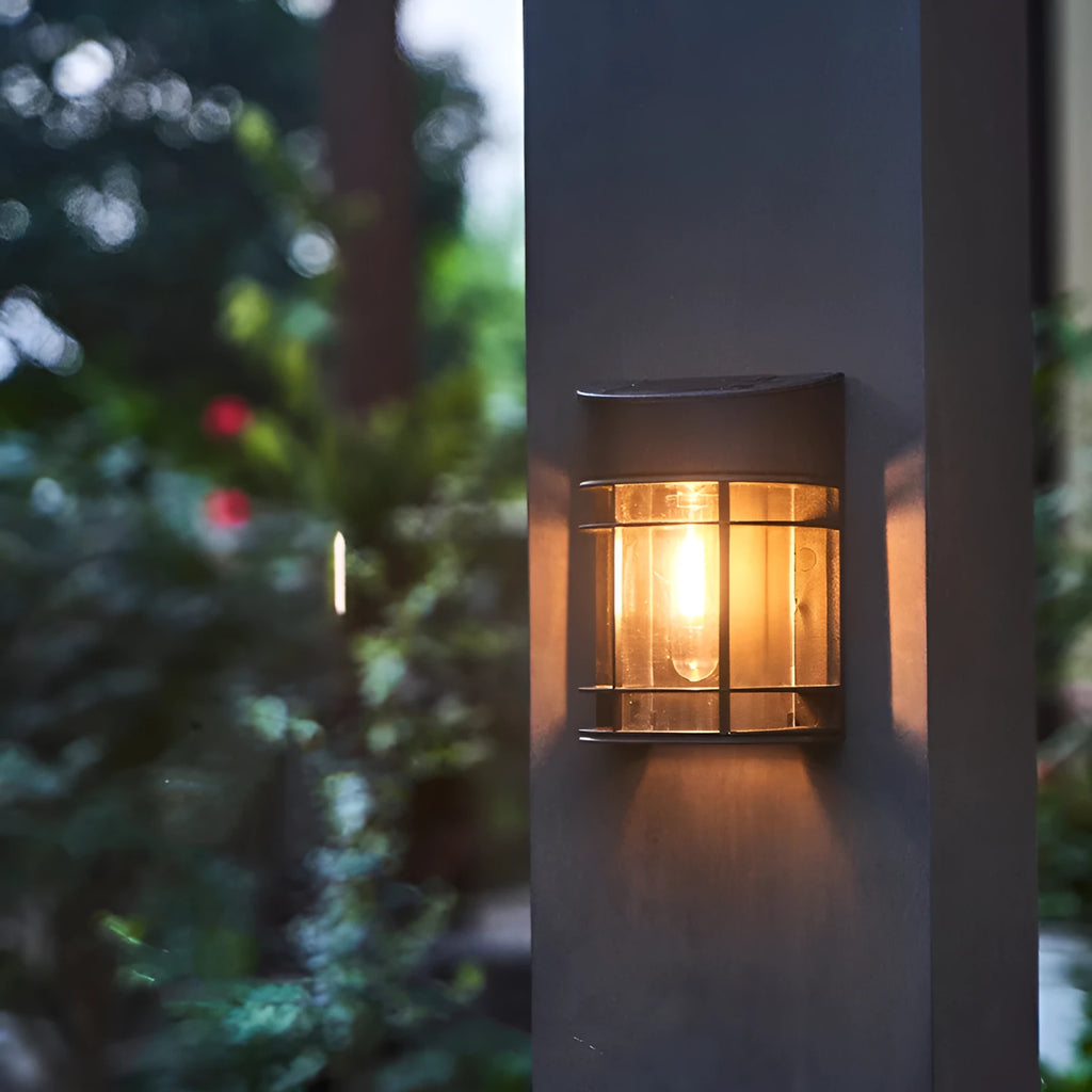 Small solar-powered outdoor wall light with warm white glow, mounted on an exterior wall.
