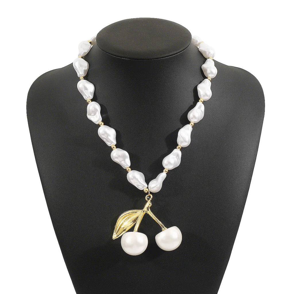 Gold irregular cherry fruit pendant on an adjustable imitation pearl chain necklace for women.