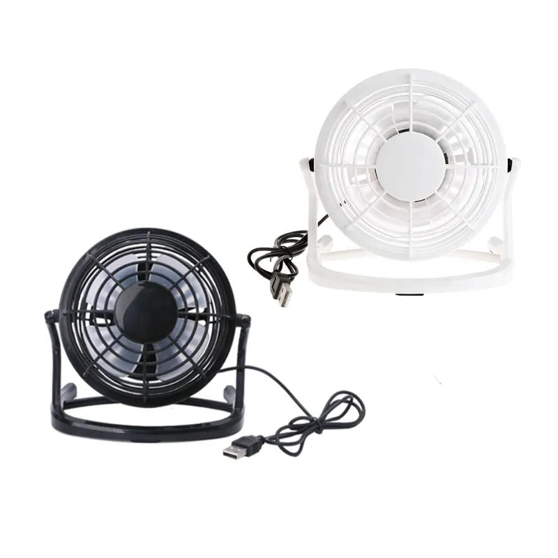 Mini adjustable tilt USB desk fan in black, shown on a desk next to a laptop