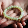 Green Hetian jade bracelet with vintage ethnic style beads on a string.