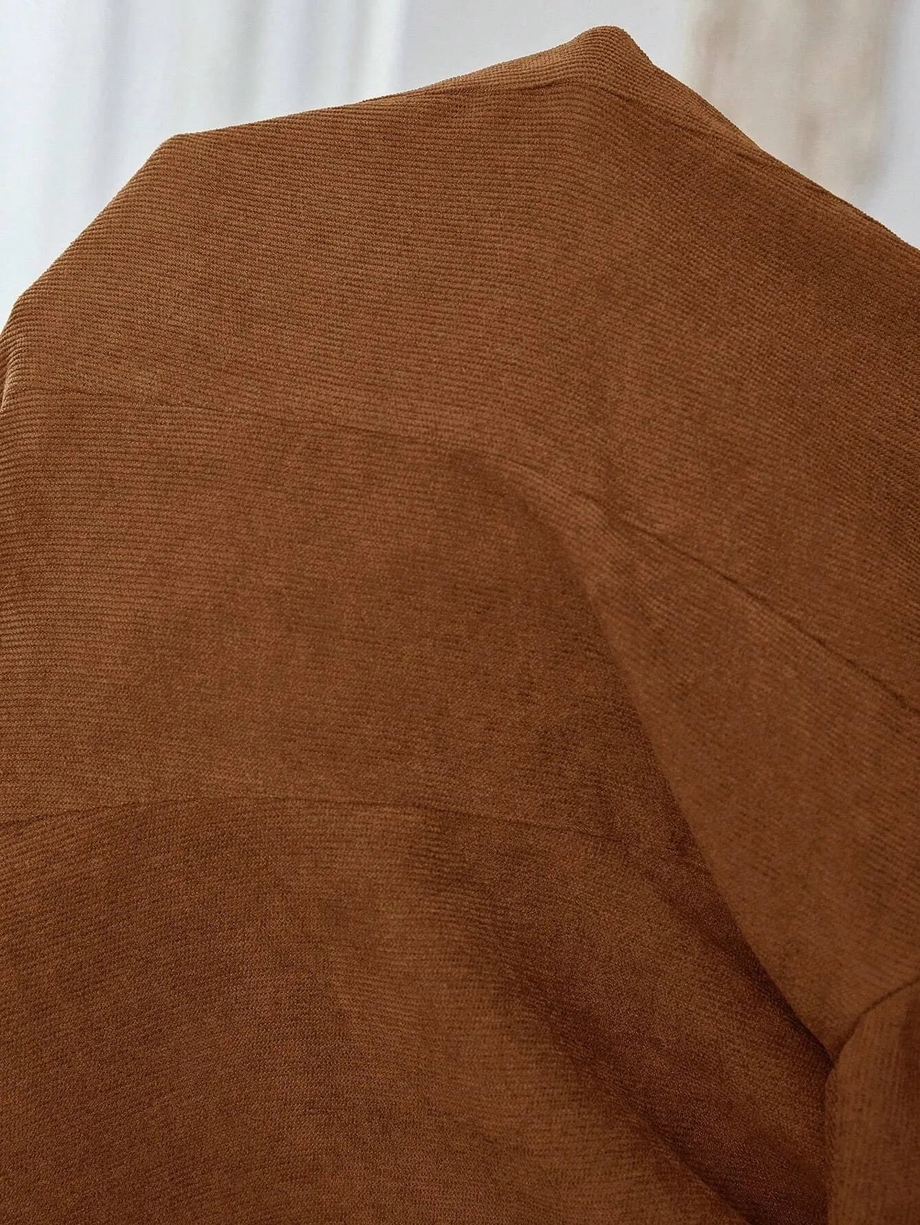 Brown men's single-breasted blazer with lapel collar and long sleeves on a hanger.