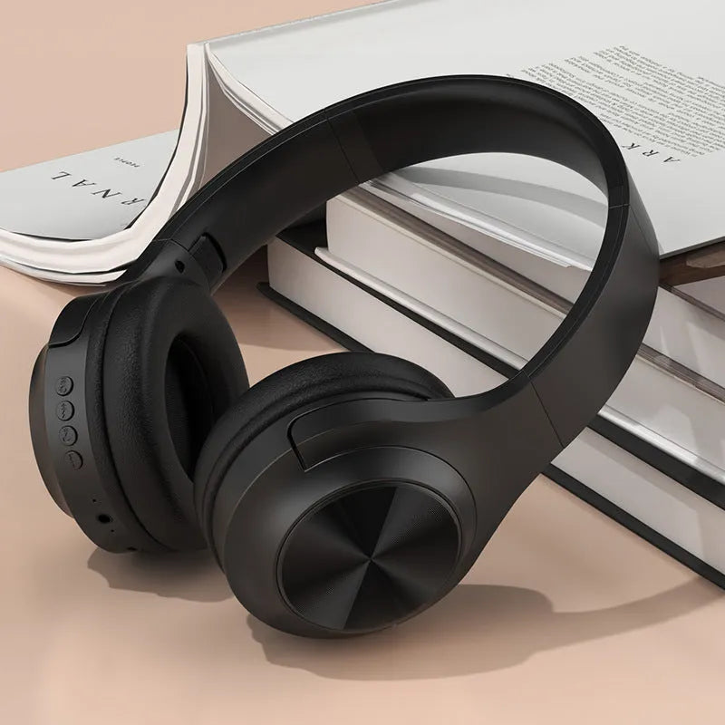 Over-ear wireless Bluetooth headset in Ivory White with a matching charging case on a table.