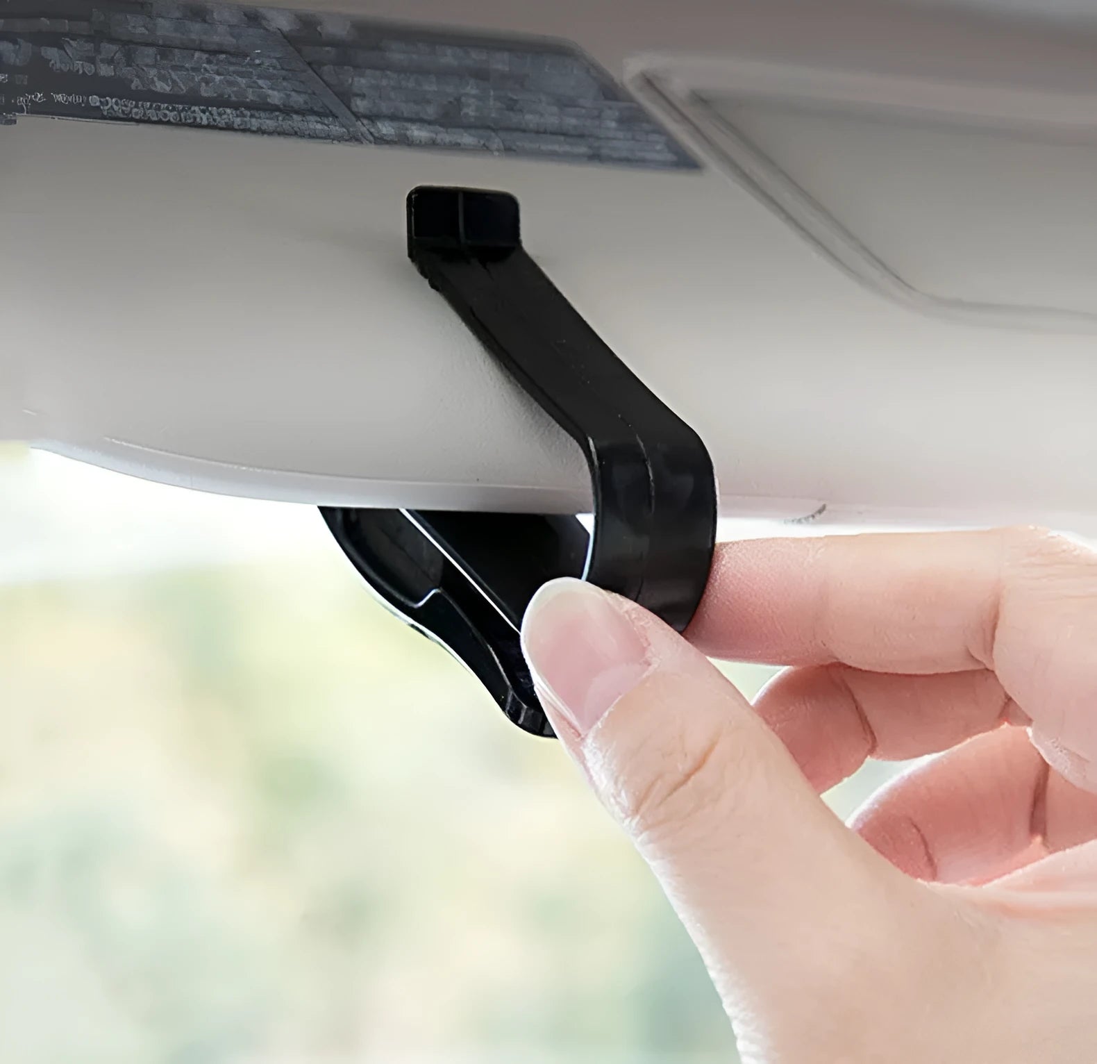 Black plastic car sunshade clip for holding glasses and cards, measuring 6.5 by 2.3 centimetres.