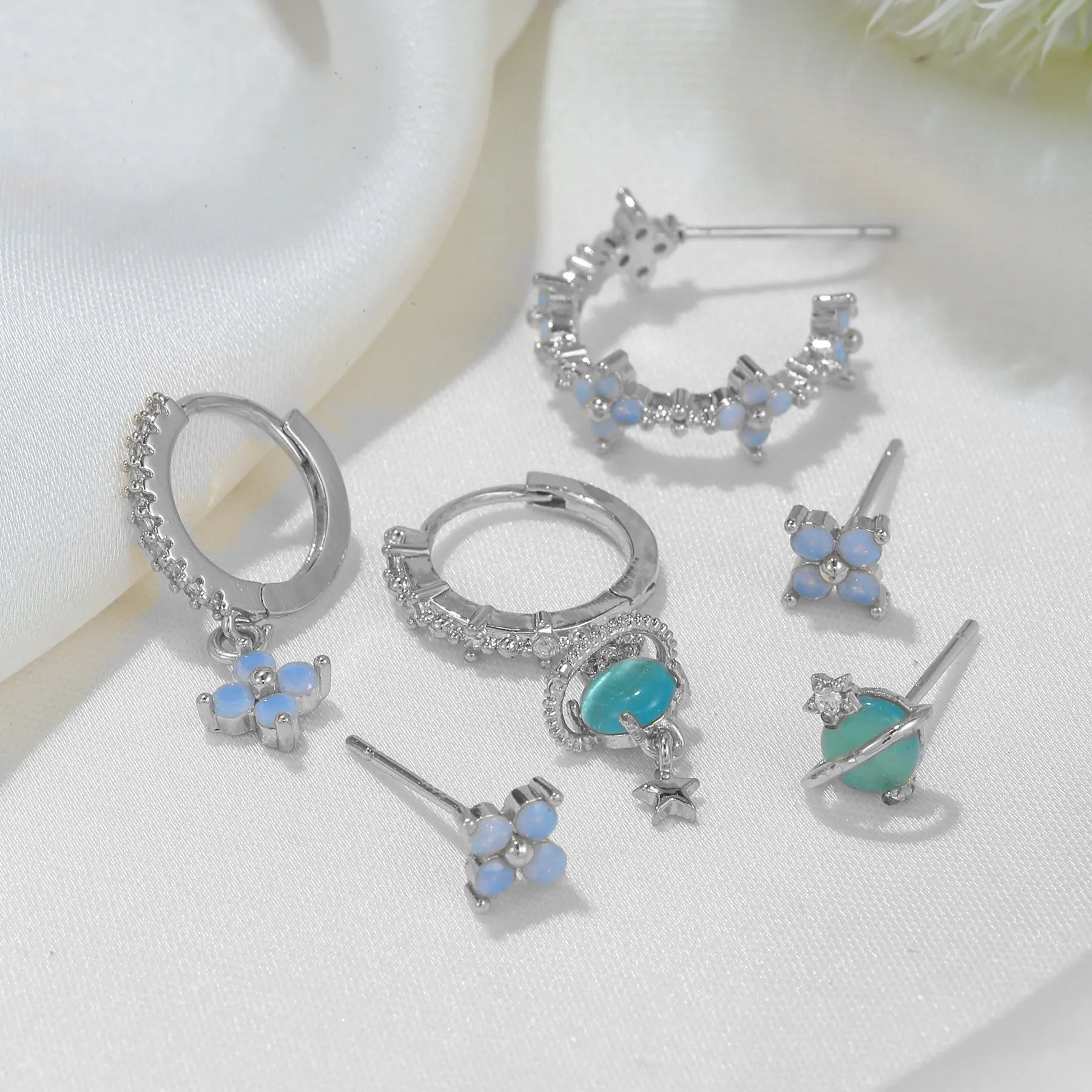 Gold and silver Japanese Korean style ear studs with blue flower nail design and zircon detail