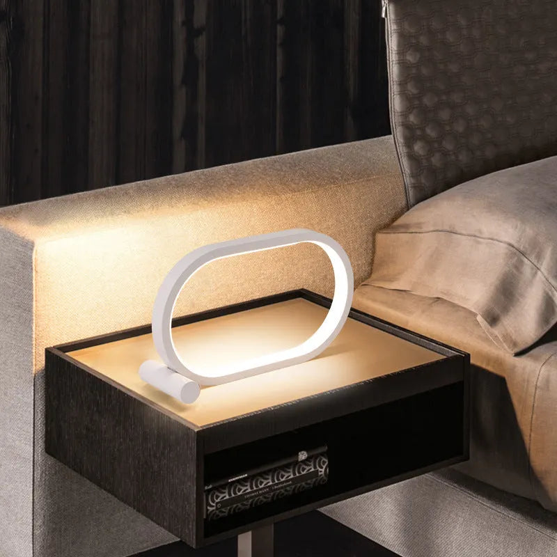 USB plug-in oval acrylic touch dimmable night light with metal base on a desk, black colour
