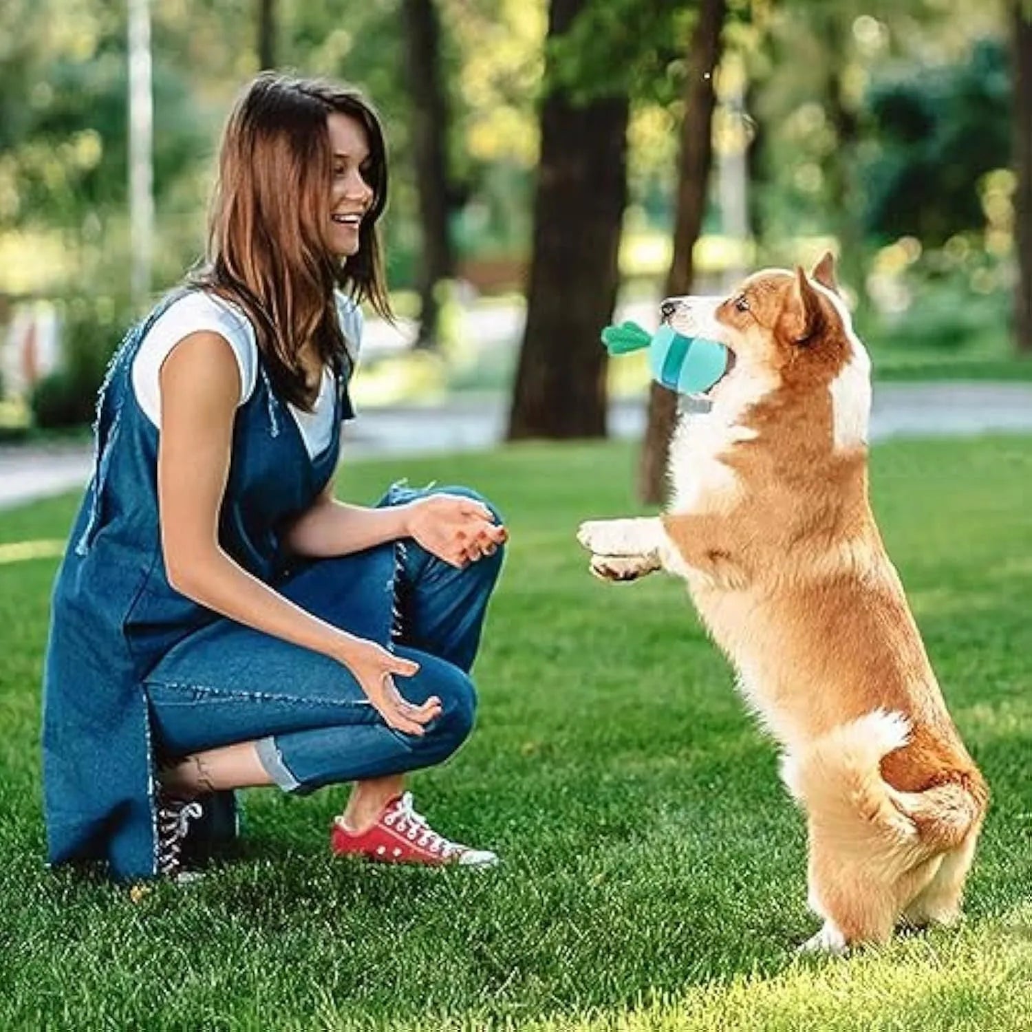 Blue durable rubber tumbler ball dog toy with small treat holes on a plain background.