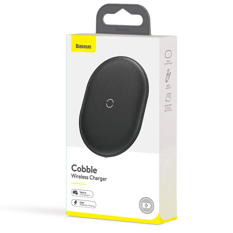Baseus Rough 15W wireless charging pad in black on a table next to a mobile phone.