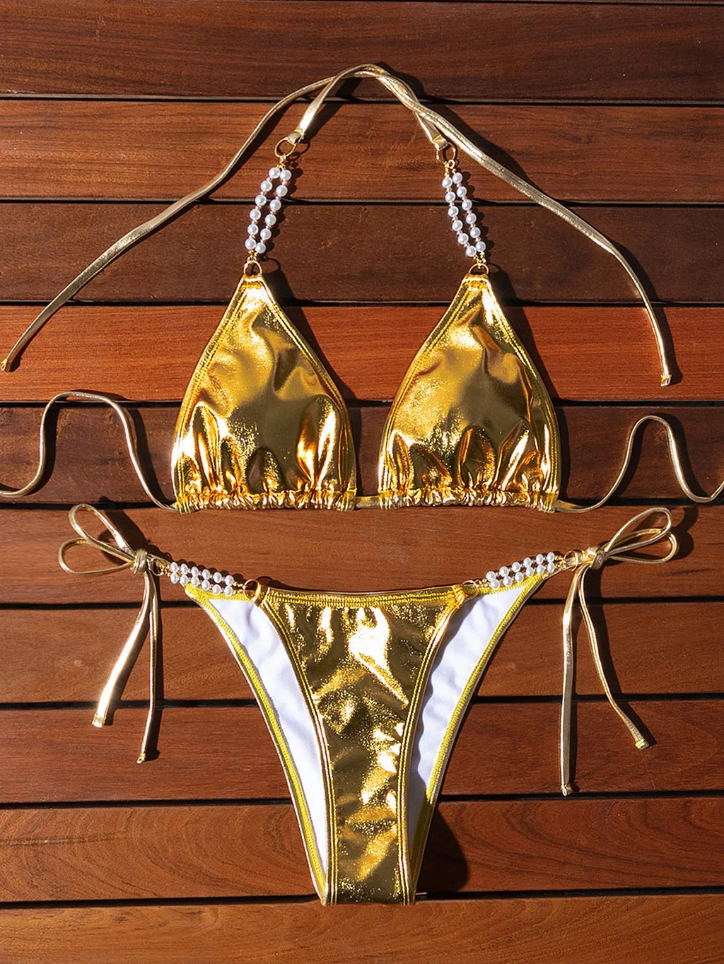 Gold halter neck bikini with lace-up front and pearl chain decoration